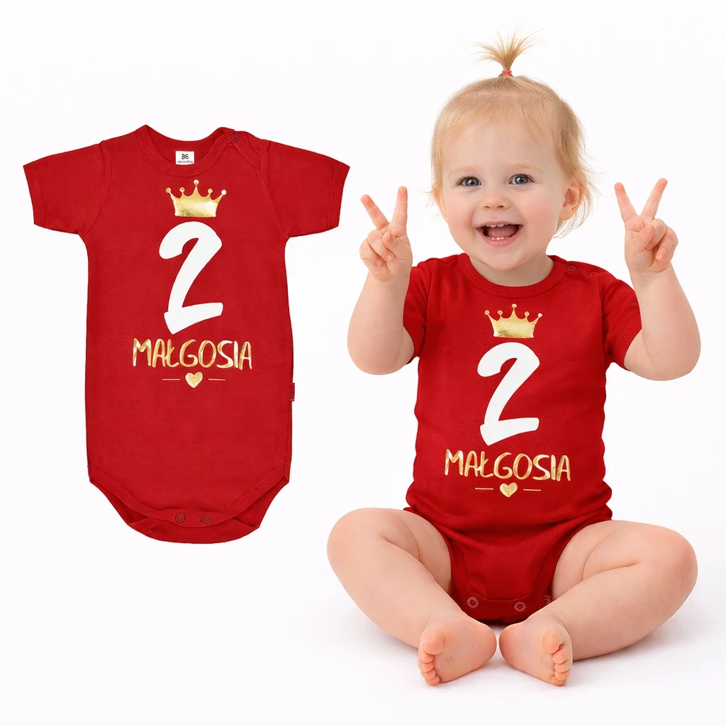 dziewczynka w czerwonym body dziecięcym z białą cyferką dwa. Na paluszkach pokazuje ile ma latek